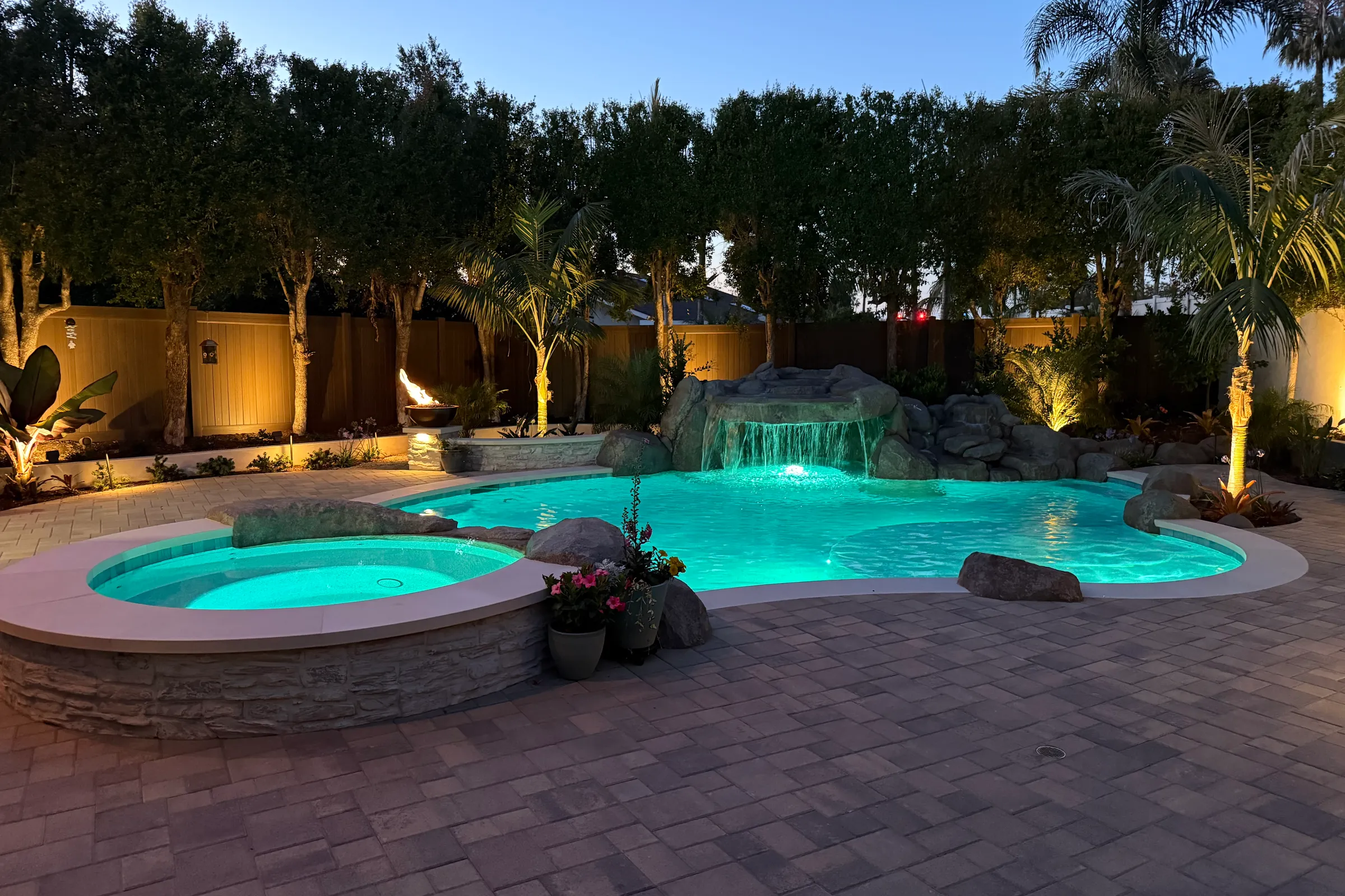 Twilight pool and outdoor living space by Artisan Outdoor